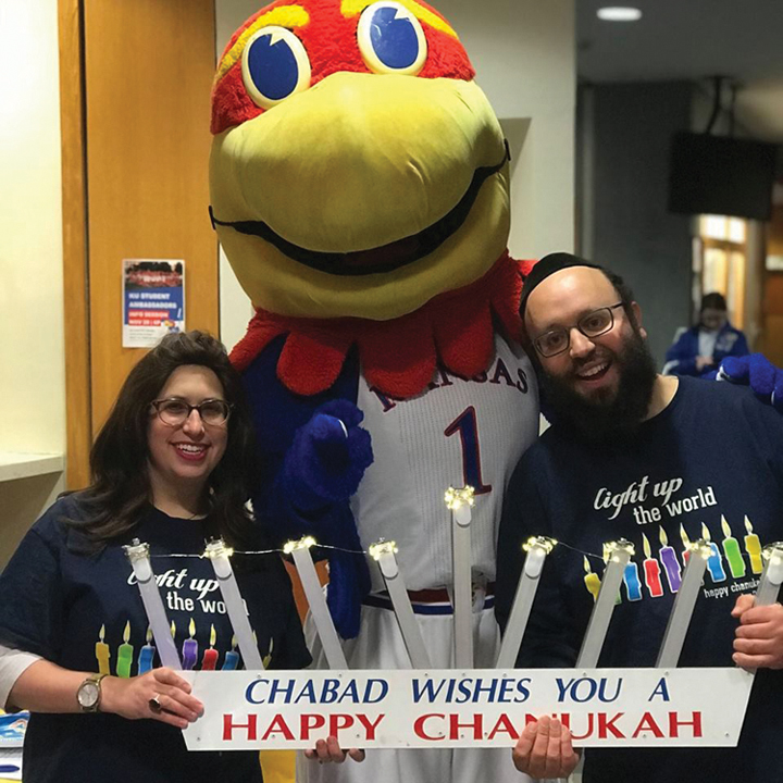 KU’s Big Jay helps Nechama and Rabbi Zalman Tiechtel celebrate Hanukkah on the university’s campus.