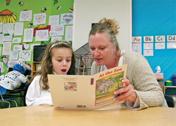 Once upon a time… HBHA Principal Gayle Gray beams with pride as kindergartner Livia Noorollah shows off her acquired reading skills. Students have been working in high frequency words, decoding and increasing fluency.