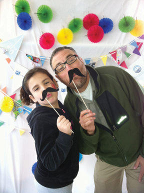 Photo provided by PJ Library: Yes, even rabbis in our community have time to have fun at the Jewish Arts Festival. Here Rabbi David Glickman has a light moment with his daughter Ellie in this photo taken in the PJ Library booth.